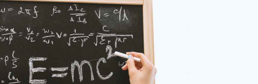 person holding a chalk in front of the chalk board